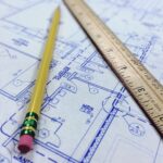 Na obrázku sa nachádza projekt pasívneho domu, ceruza a pravítko.